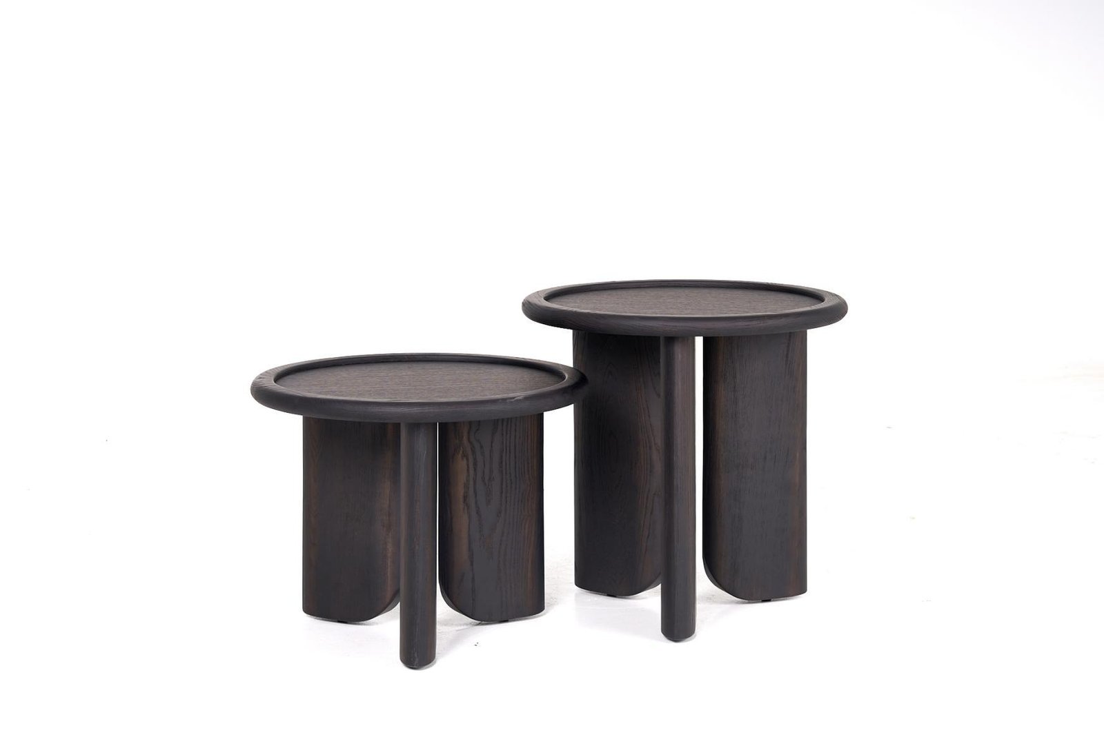 Two dark round coffee tables of different heights arranged with partly overlapping tops