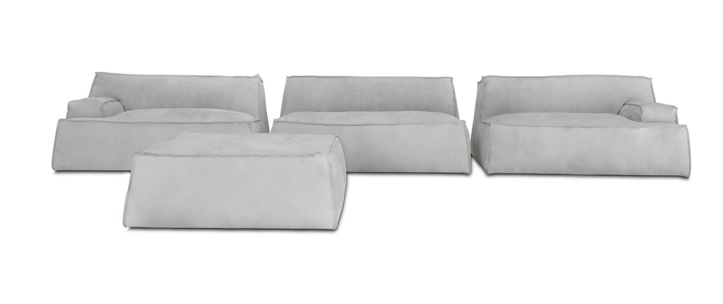 Separate pale sofa modules with loose cushions and a matching upholstered ottoman