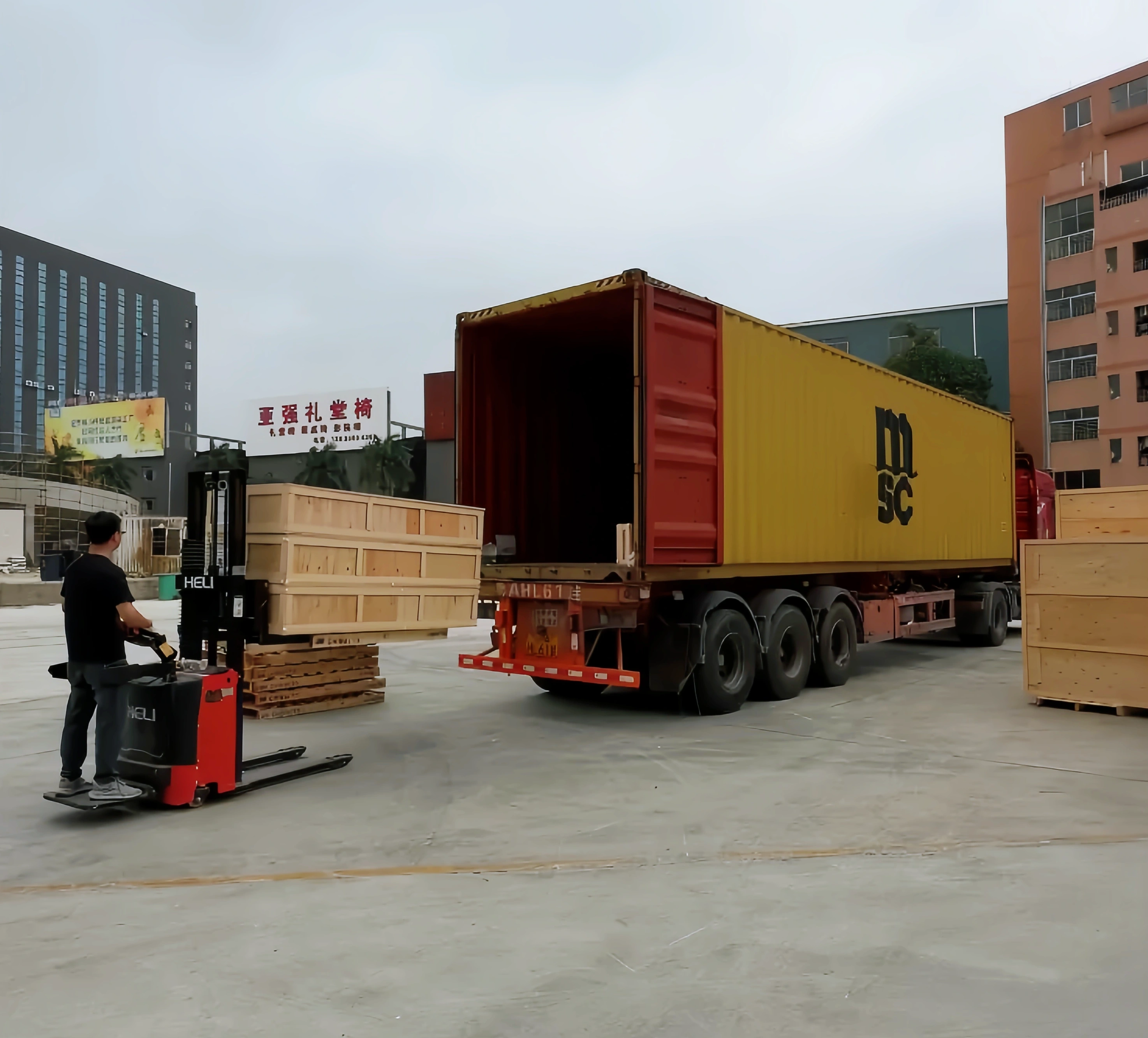 Wooden furniture crates being loaded beside a shipping container
