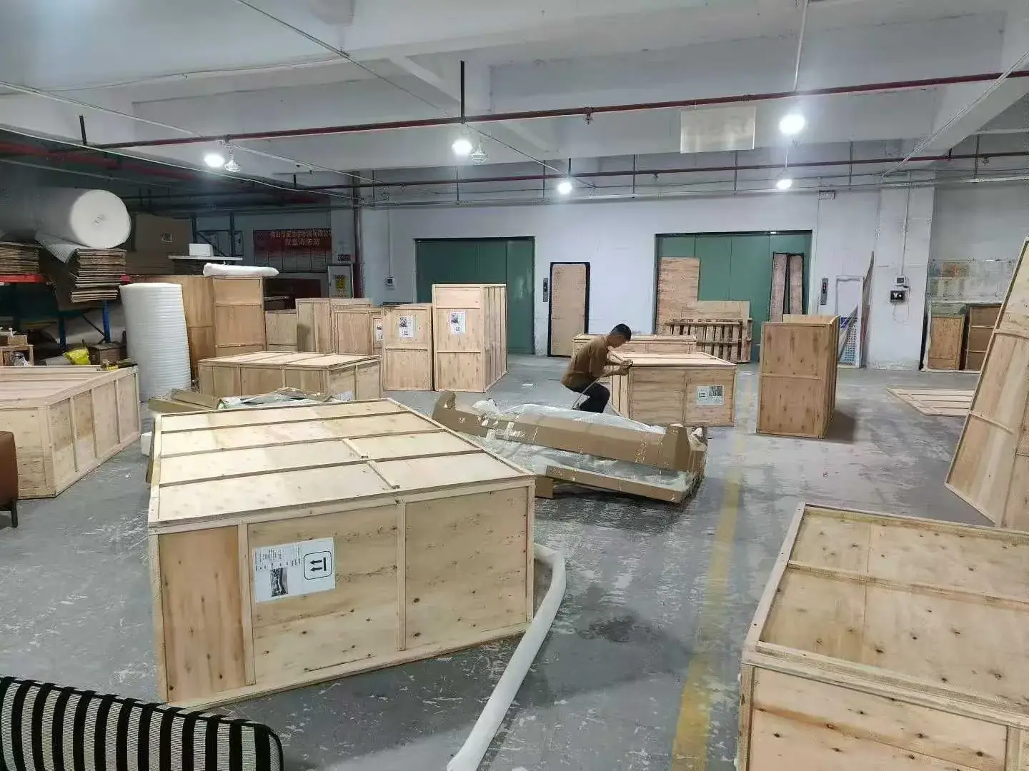 Wooden crates and wrapped furniture components in a workshop packing area