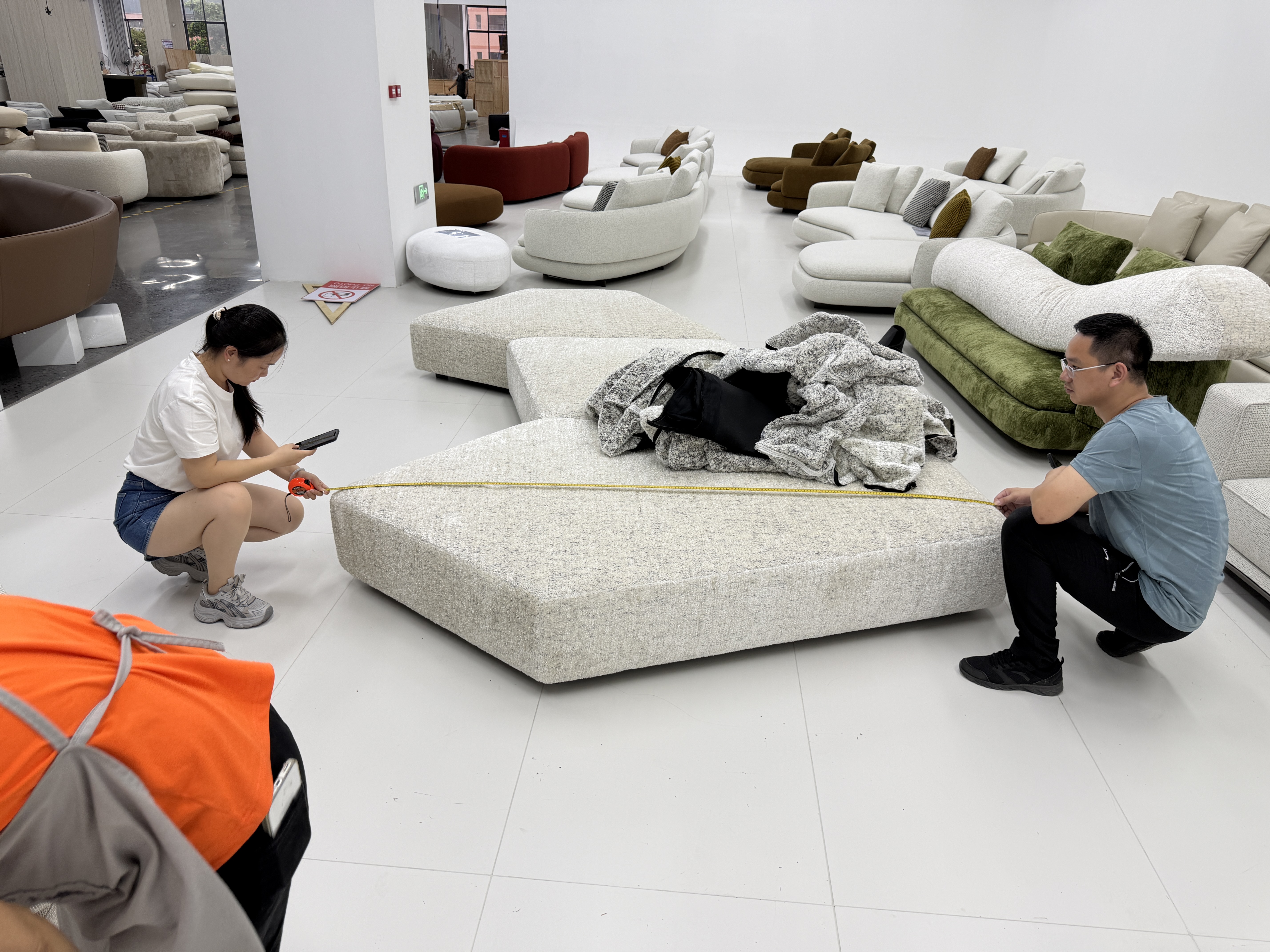 Workers handling an upholstered sectional component in a furniture workshop