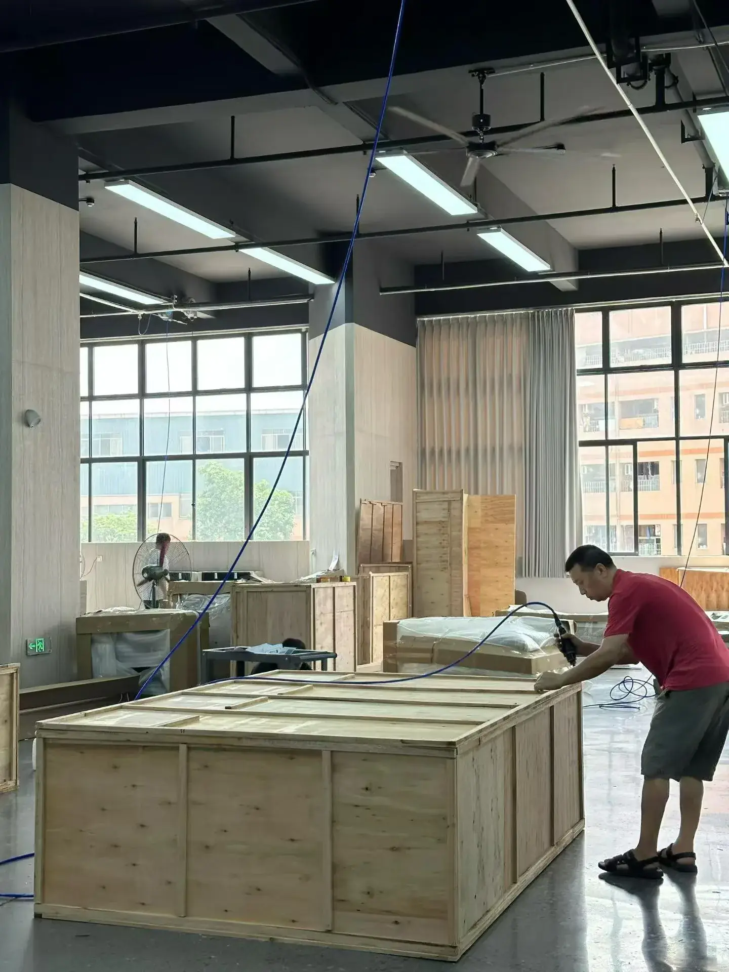 Worker assembling a wooden furniture crate in a workshop