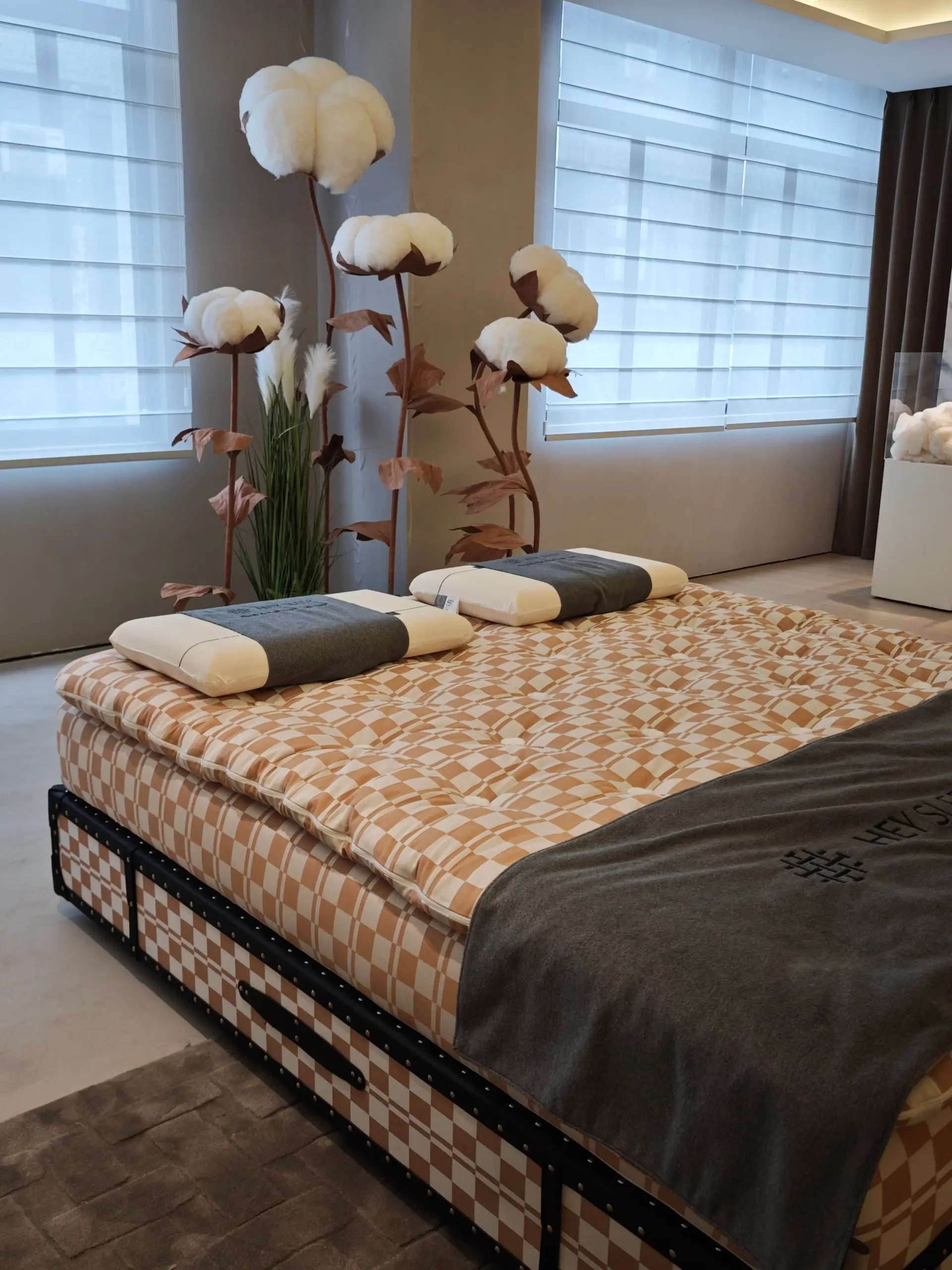 Tufted mattress with a patterned cover shown on a bed base