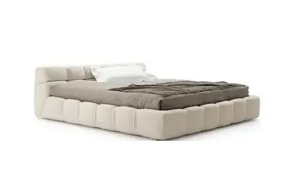 Cream upholstered platform bed with a tufted low-profile frame