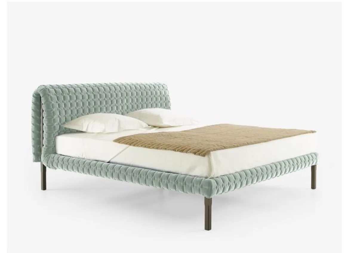 Green textured upholstered bed with a wide padded headboard and slim support legs