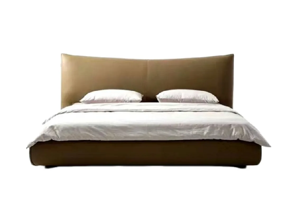 Upholstered bed frame with bedding and a broad panelled headboard