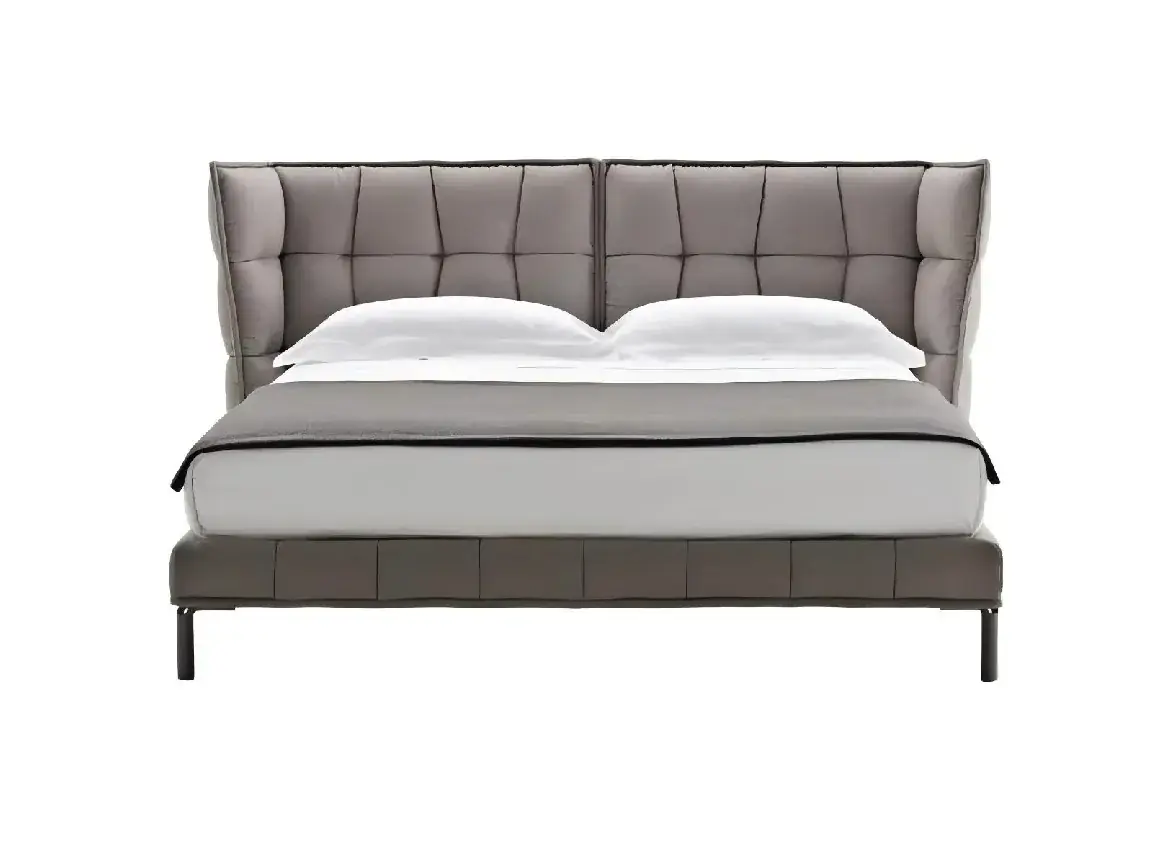 Grey upholstered bed with a grid-tufted wingback headboard and slim dark feet