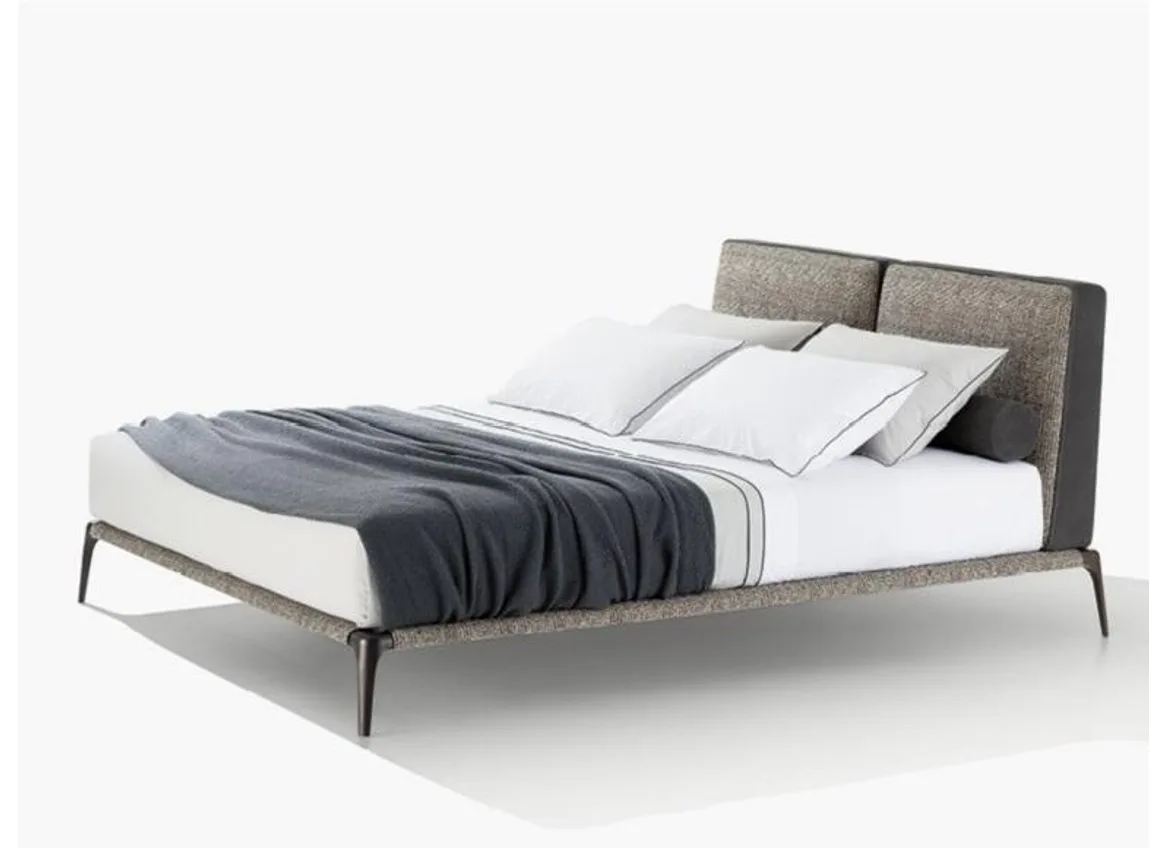 Raised upholstered bed frame with slim legs and open floor visible beneath the side rail