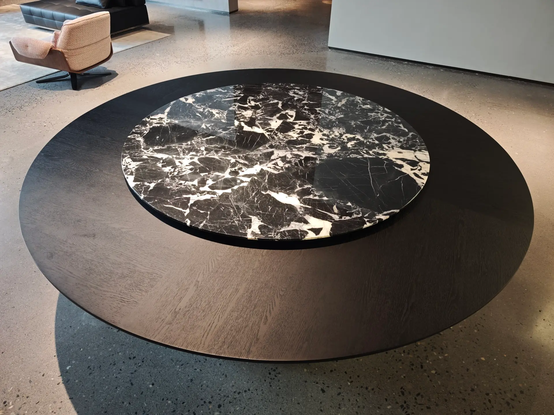 Round marble dining table with a dark wood frame and lower tier