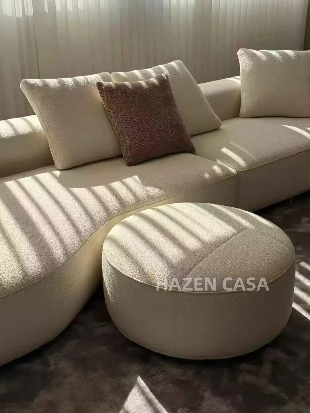 Close view of sofa seat cushions, loose back cushions and an upholstered ottoman