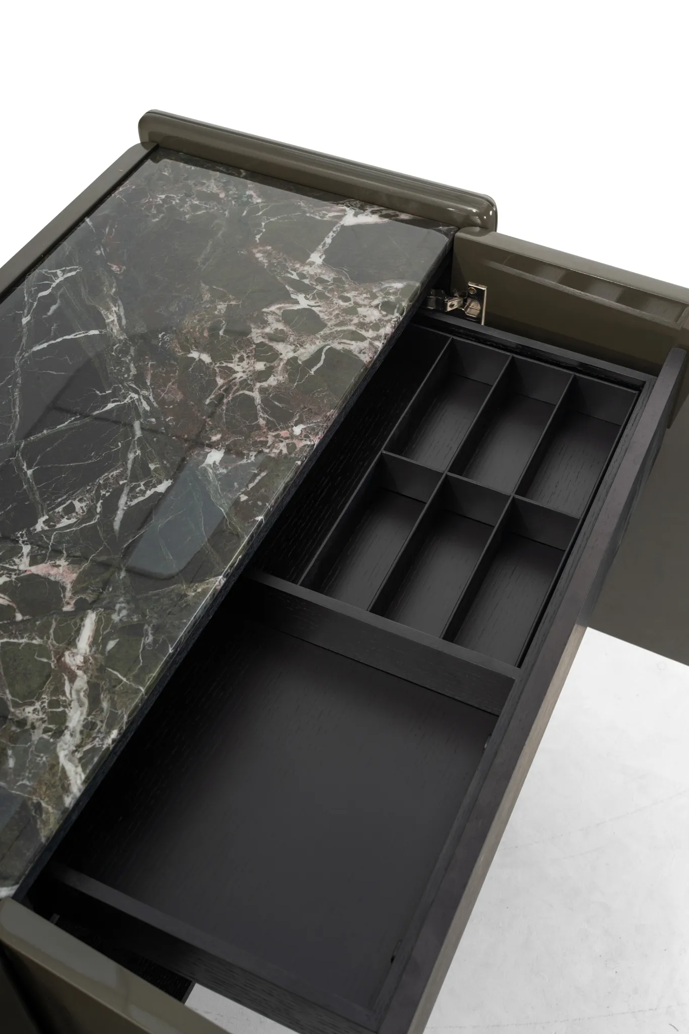 Open drawer compartments beneath a veined cabinet top