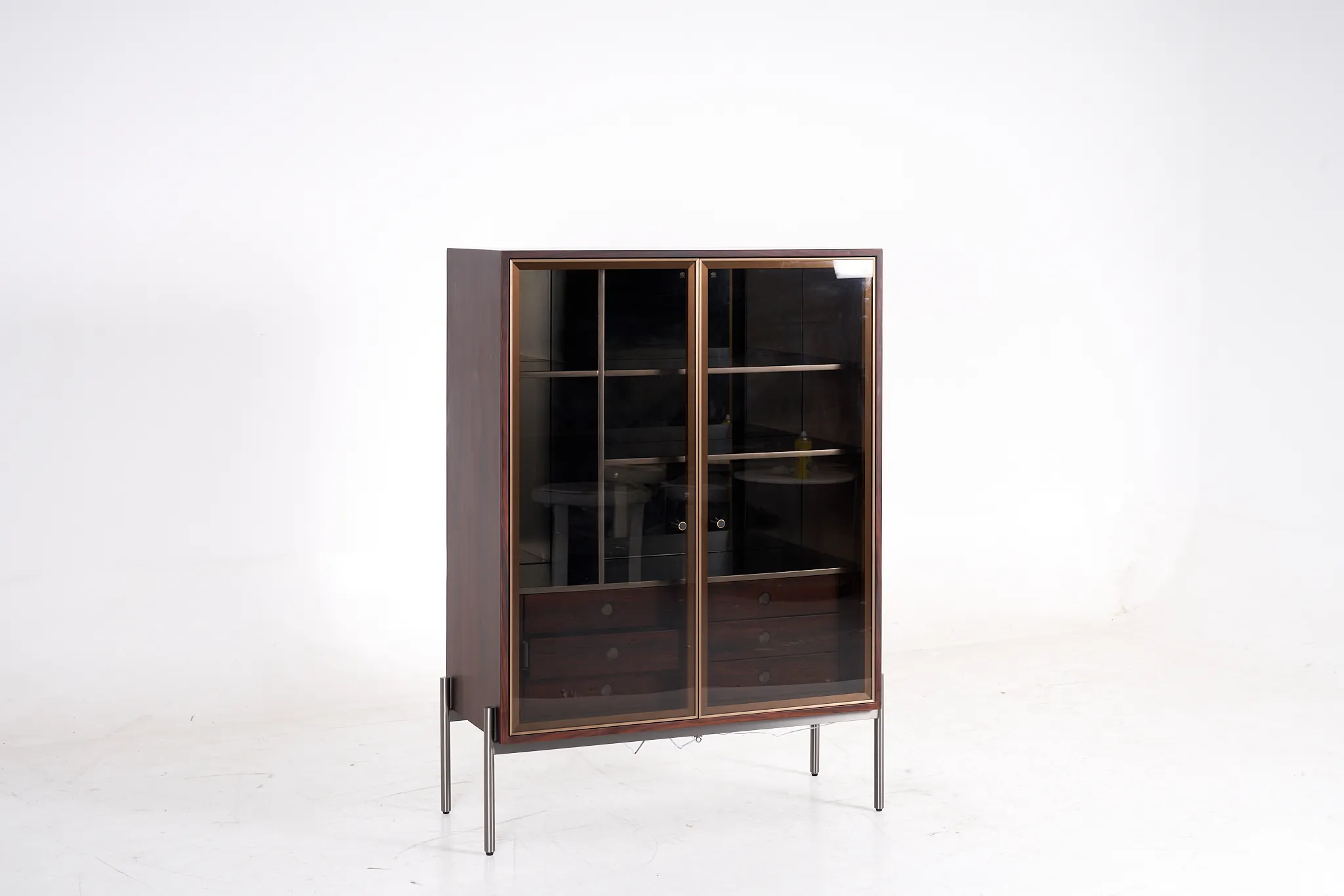 Tall glazed storage cabinet with dark shelves, wood-toned sides and slim raised legs
