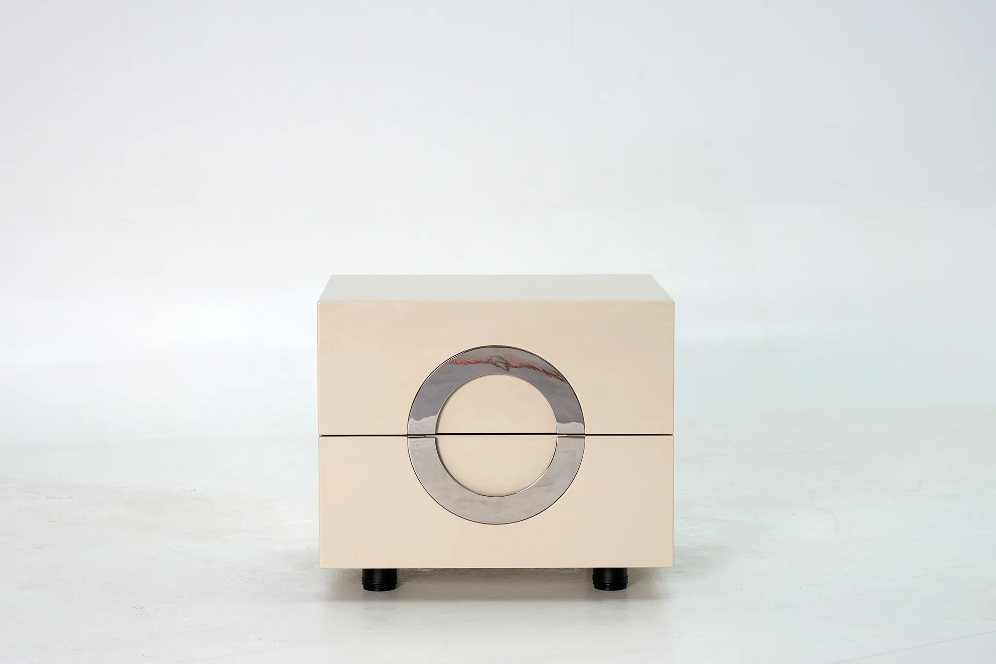 Light bedside cabinet with a circular front detail and short dark feet