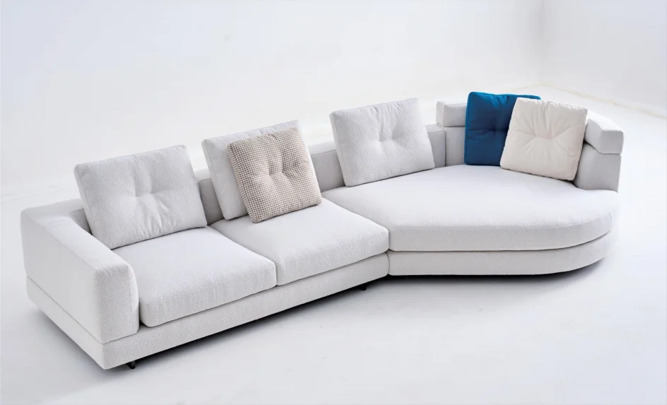 White sectional sofa with a curved projecting section on the right when viewed from the front