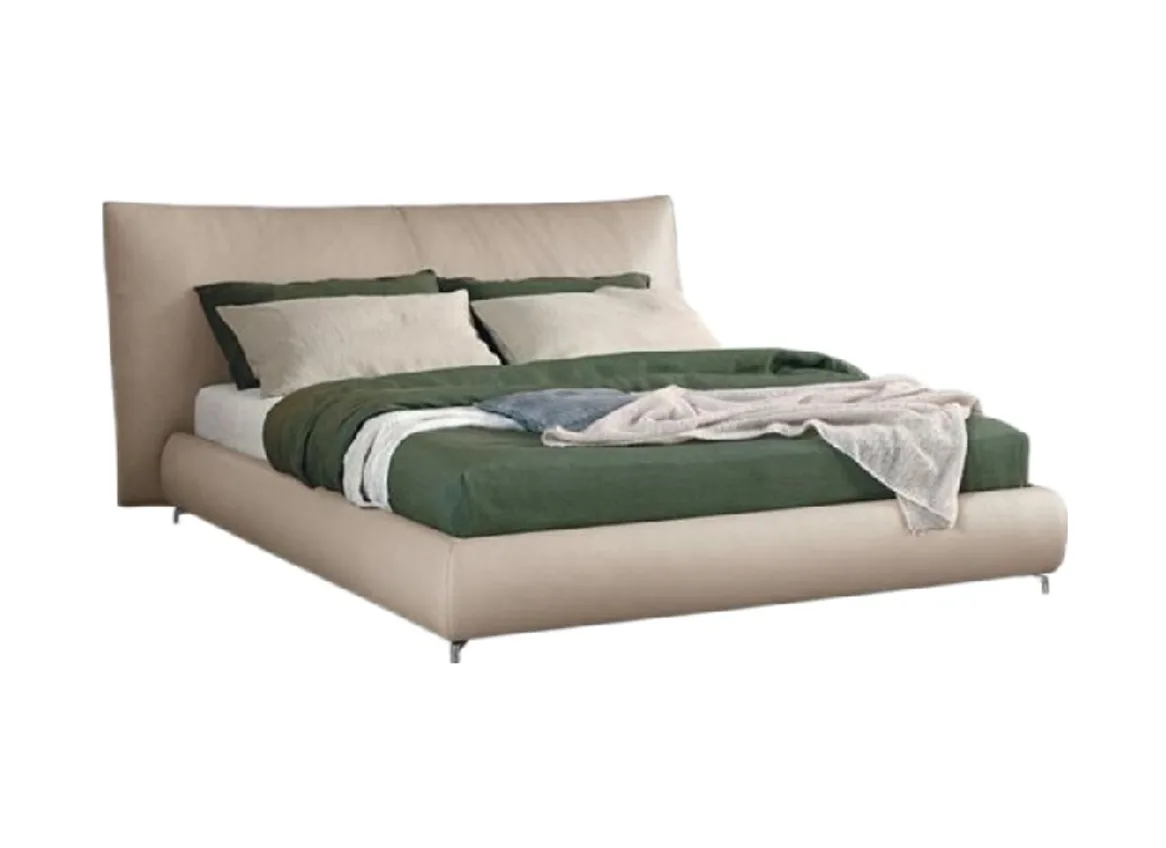 Upholstered bed with a broad split headboard, pillows and a made-up mattress
