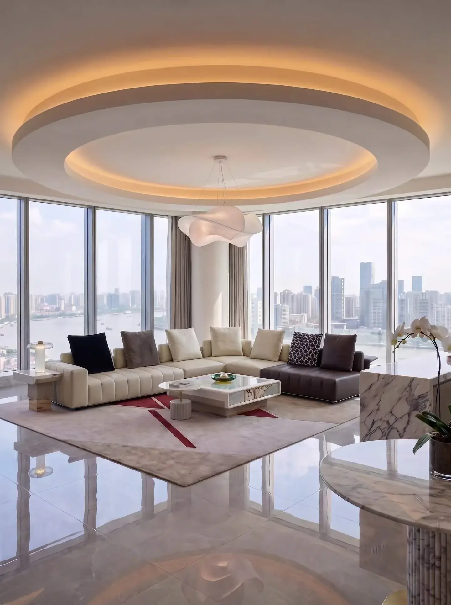 Sofa grouping defining a sitting area within a bright apartment with broad city-facing windows
