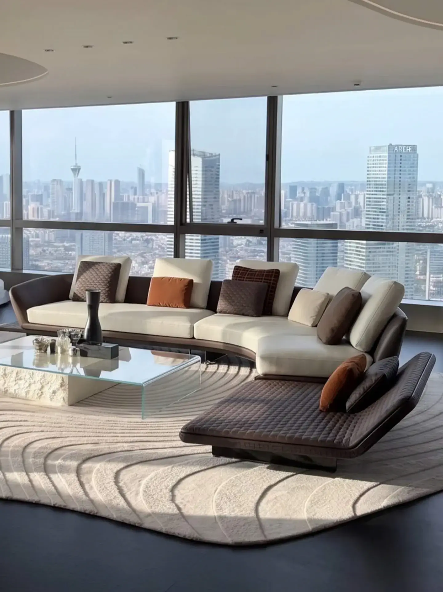 Low upholstered seating arranged beside a wall of large windows overlooking a city