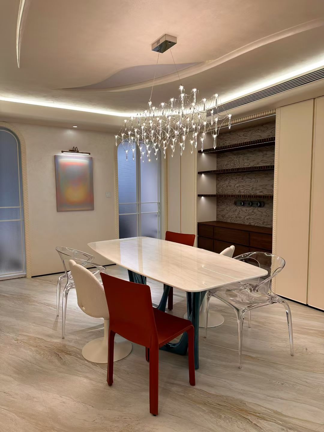 Rectangular dining table surrounded by chairs beside built-in storage in a furnished room