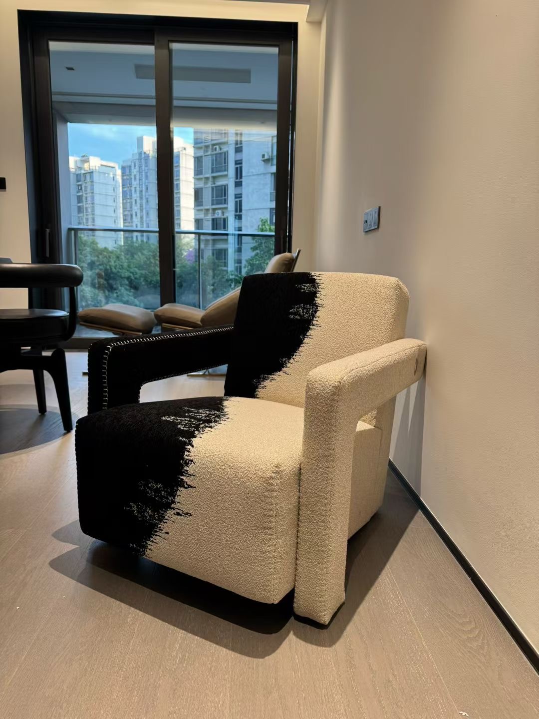 Single lounge chair placed beside a tall window in a small seating corner